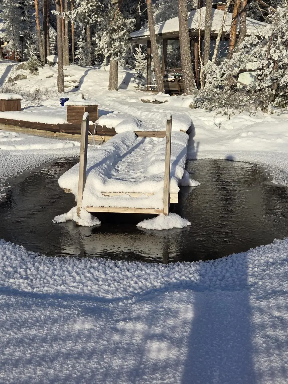 Pulpun pitämä avanto laiturin ympärillä lumisena pakkaspäivänä